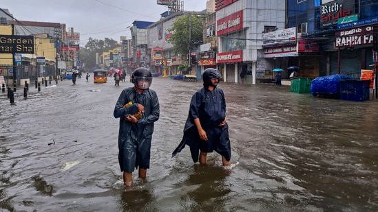 People wade through a waterlogged road during heavy rain owing to Cyclone Michaung, in Chennai (PTI)